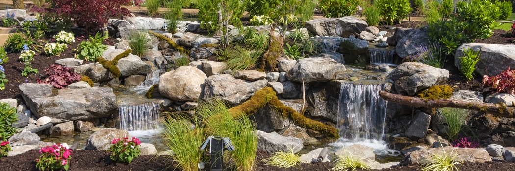 Landscaped rock waterfall with flowers and greenery